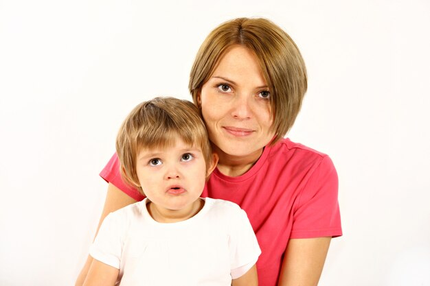 Joven madre e hija sobre fondo blanco.