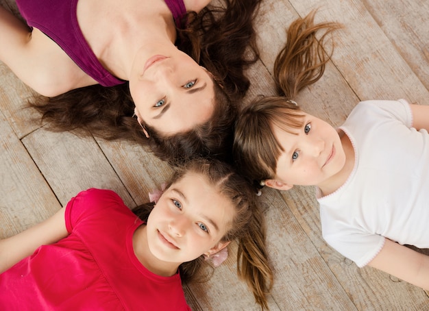 Joven madre e hijas tumbadas en el suelo