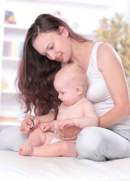 La joven madre enseña al bebé a ponerse de pie. el concepto de maternidad