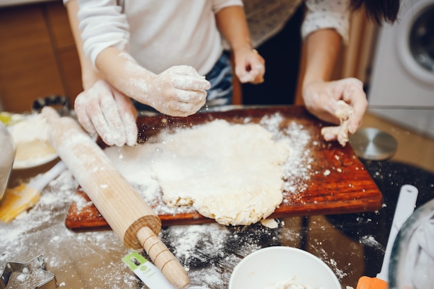 una joven madre está preparando comida en casa en la cocina con su pequeño hijo