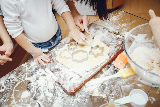 una joven madre está preparando comida en casa en la cocina con su pequeño hijo