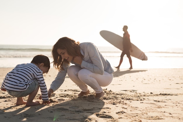 Joven madre explorando la playa con un niño pequeño
