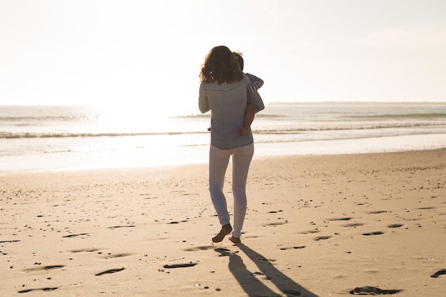 Joven madre explorando la playa con su bebé