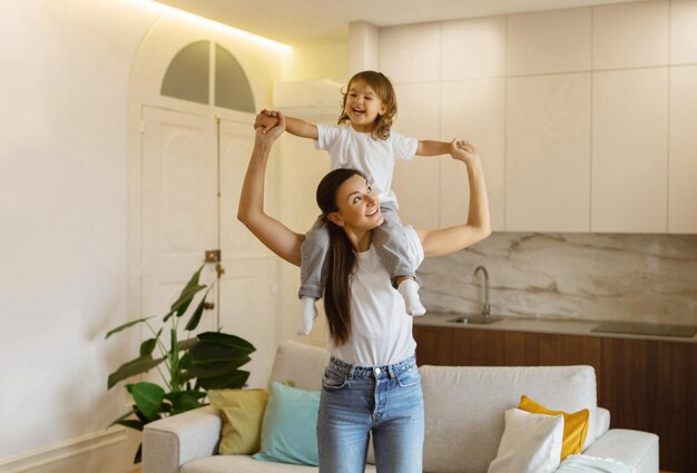 Foto una joven madre feliz y su hija en edad preescolar juegan juntas en casa