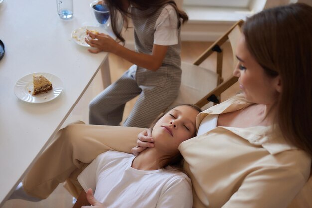 Foto una joven madre con una hermosa hija bebe té en la cocina