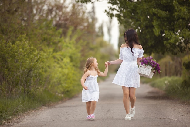 Joven madre hermosa y pequeña hija divirtiéndose juntos