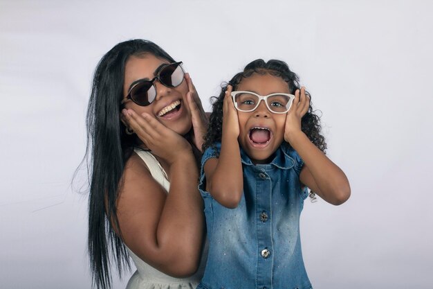 Joven madre con hija en estudio fotográfico sobre fondo blanco para recortar