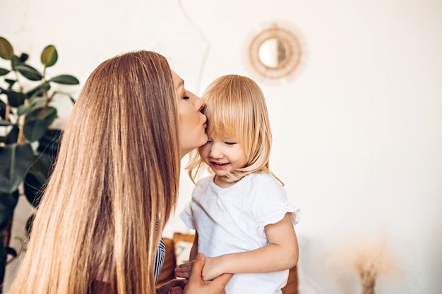 Joven madre jugando con niño pequeño en casa