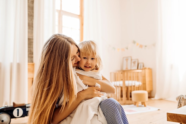 Joven madre jugando con niño pequeño en casa