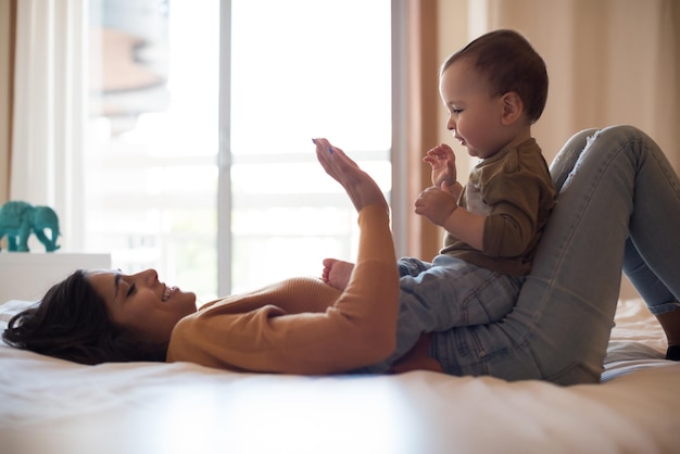 Joven madre jugando con su bebé en casa