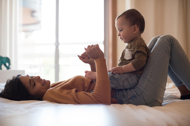 Joven madre jugando con su bebé en casa