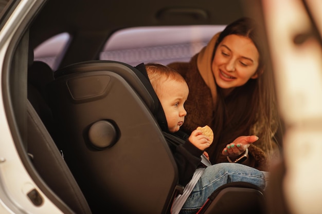 joven, madre, y, niño, en coche, asiento de bebé, en, silla, seguridad, conducción, concepto