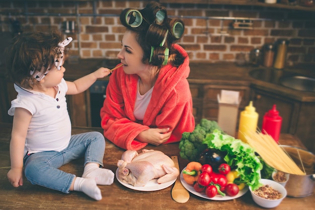 Joven madre con niño pequeño en la cocina de casa