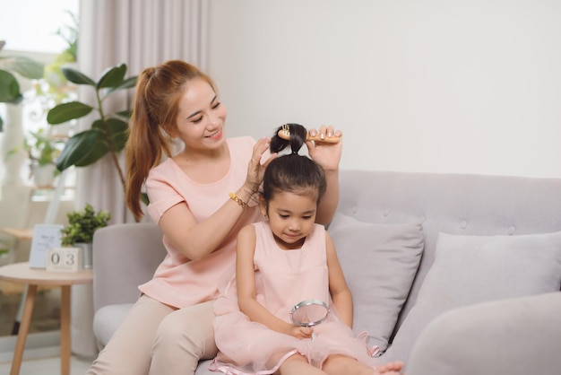 Una joven madre peinando a una niña