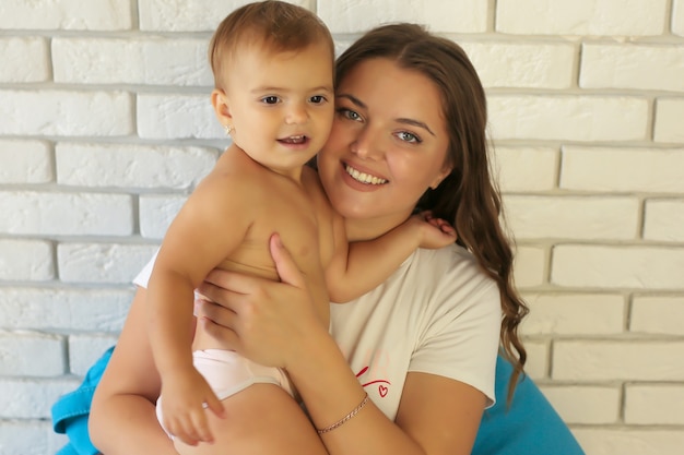 una joven madre de pelo largo abraza a su pequeña hija