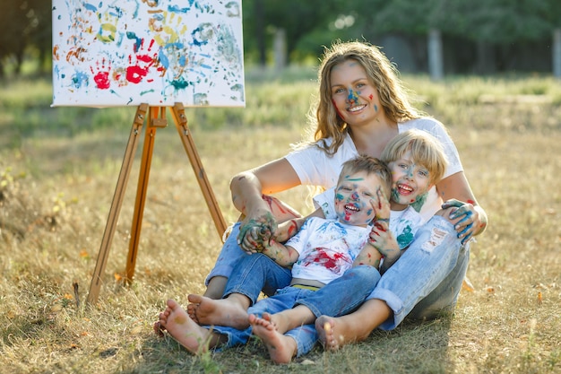 Foto joven madre pintando con sus hijos