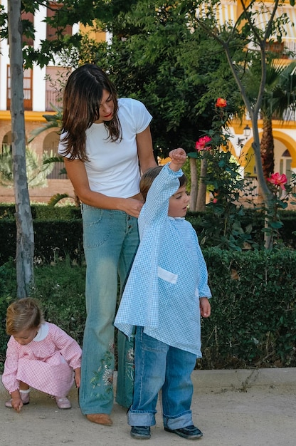 Joven madre preparando y llevando a sus hijos a la escuela y al jardín de infantes.