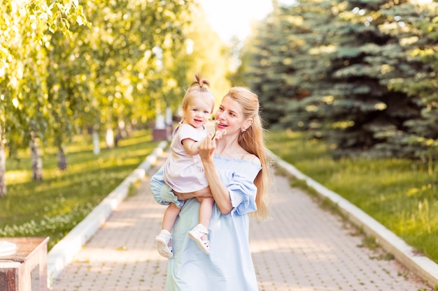 Joven madre rubia hermosa con su niña riendo juntos