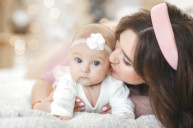 joven madre sosteniendo a su pequeña bebé linda.