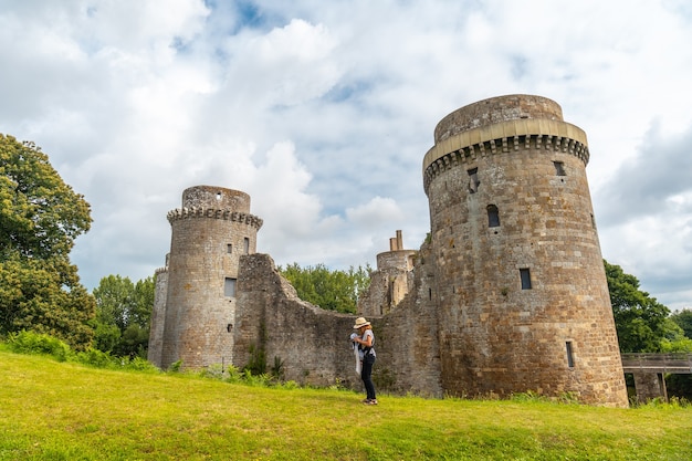 Una joven madre y su bebé visitando las murallas del castillo medieval de Hunaudaye, Bretaña francesa. Monumento histórico de Francia