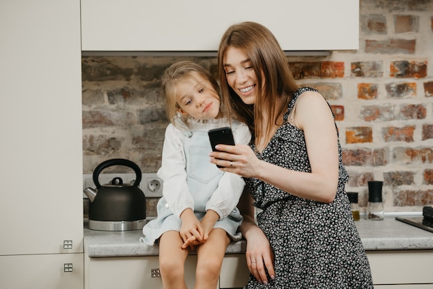 Joven madre con su hija en la cocina