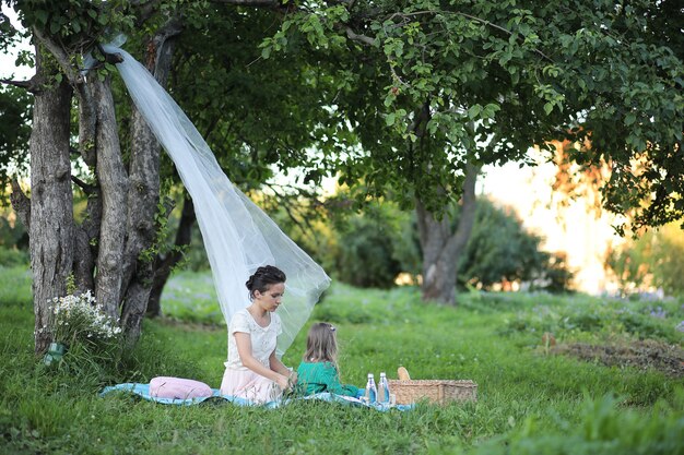 Joven madre con su hija en un picnic en el parque