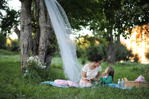 Joven madre con su hija en un picnic en el parque