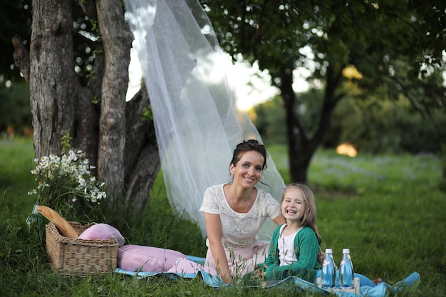 joven madre con su hija en un picnic en el parque