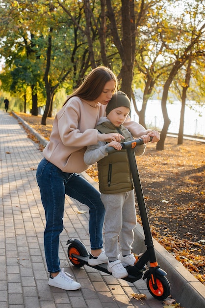 Una joven madre y su hijo viajan en segways por el parque.