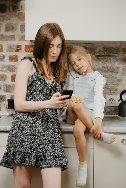 Joven madre con su linda hija en la cocina