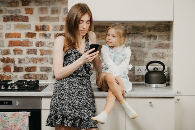 Joven madre con su linda hija en la cocina