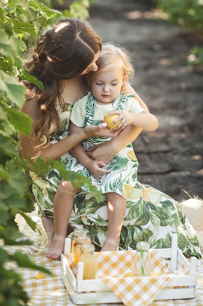 Joven madre y su pequeña hija al aire libre divirtiéndose. Bonita familia.