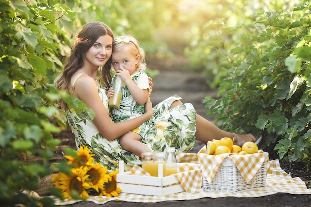 Joven madre y su pequeña hija al aire libre divirtiéndose. Bonita familia.