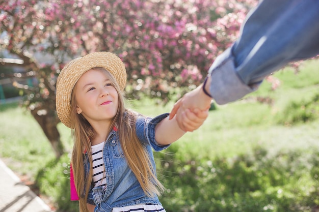 La joven madre y su pequeña y linda hija se divierten al aire libre. Chicas de familia juntas.