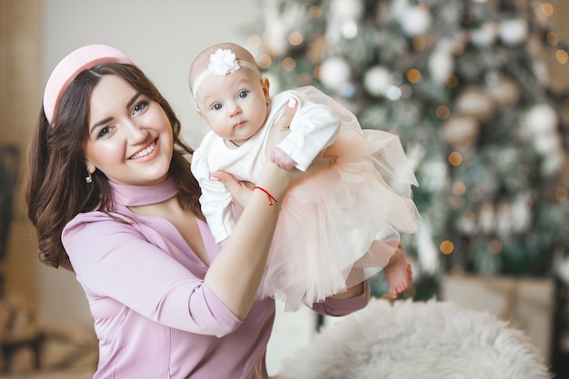 joven madre con su pequeña nena con decoración navideña