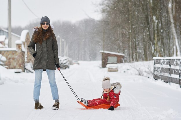 Una joven madre con sus hijos divirtiéndose en invierno.