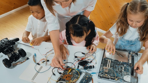 Joven maestro inteligente que enseña a estudiantes diversos sobre el tablero electrónico Erudición
