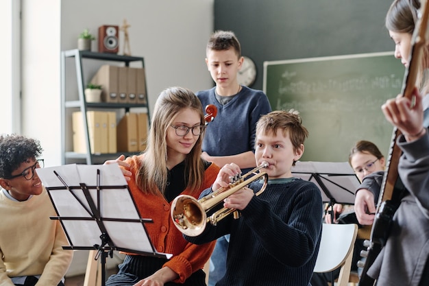 Joven maestro trabajando con la orquesta escolar