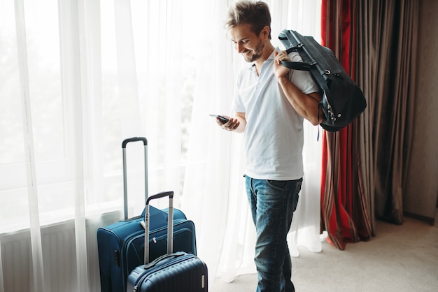 Joven con maletas se prepara para un viaje