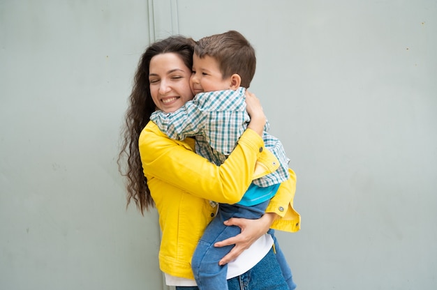 Joven mamá feliz con bebé en brazos.