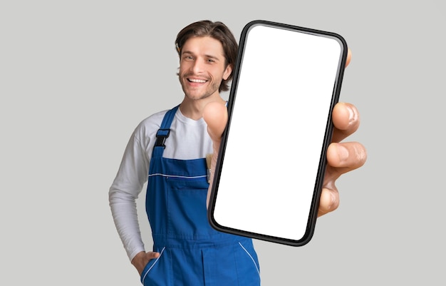 Joven manitas mostrando teléfono móvil con pantalla en blanco