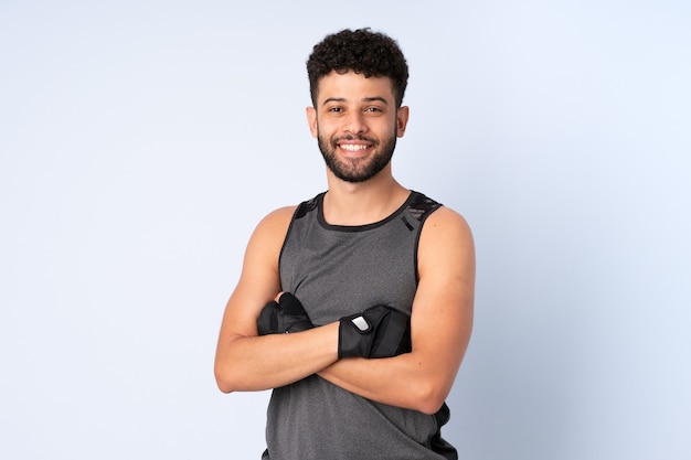 Joven marroquí aislado en la pared azul feliz y sonriente