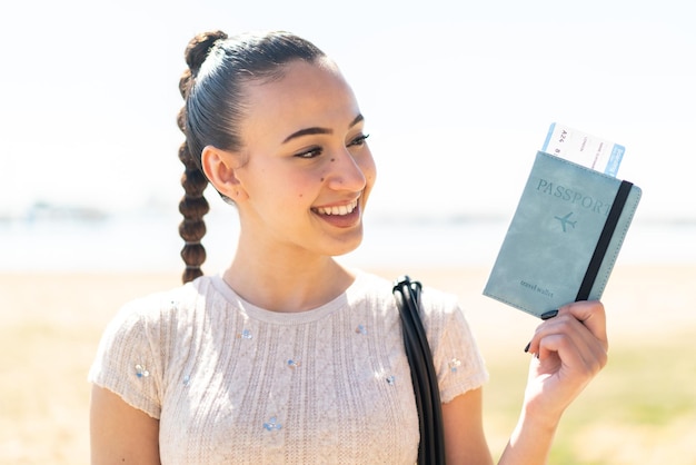 Foto joven marroquí al aire libre sosteniendo un pasaporte con expresión feliz