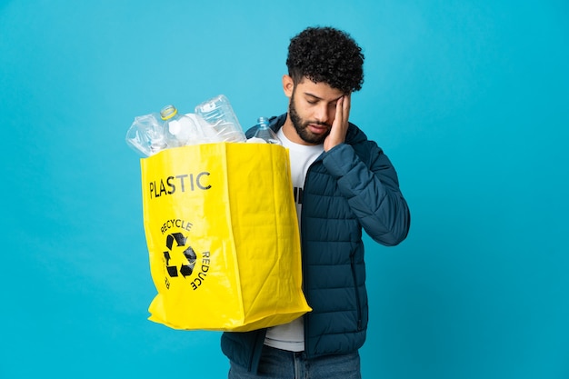 Joven marroquí sosteniendo una bolsa llena de botellas de plástico para reciclar aislado