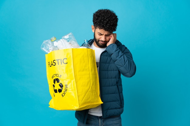 Joven marroquí sosteniendo una bolsa llena de botellas de plástico para reciclar aislado