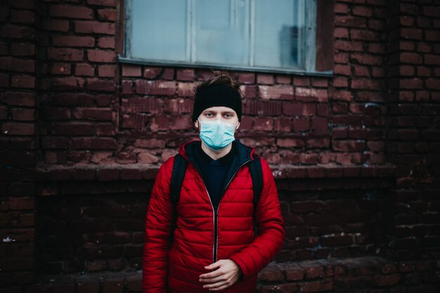 Joven con una máscara médica en una ciudad durante una pandemia