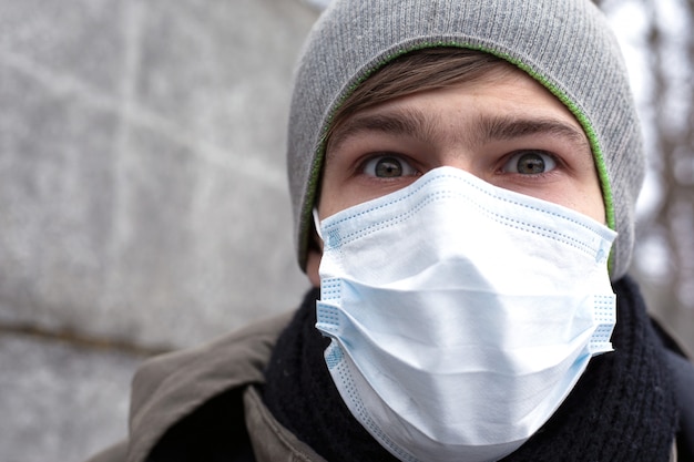 Un joven con una máscara protectora se protege del coronavirus, una pandemia del virus chino. Ncov-2019.