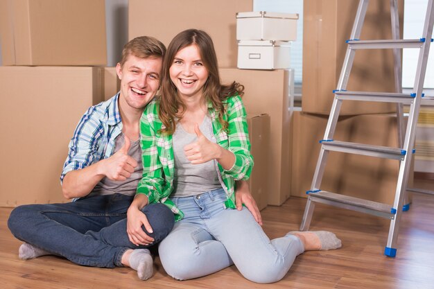 Joven matrimonio con cajas y sosteniendo llaves planas