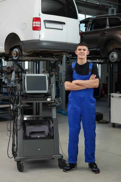 Joven mecánico de automóviles en un taller de reparación de automóviles