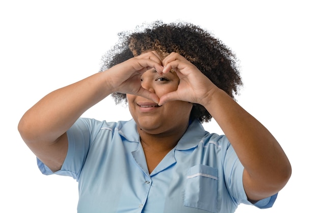 joven médica afrolatina venezolana viendo a través de un corazón lo que está haciendo con sus manos